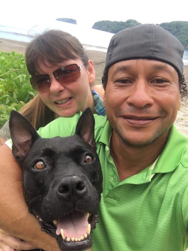 Dawn y Nolberto en la playa con uno de sus perros rescatados
