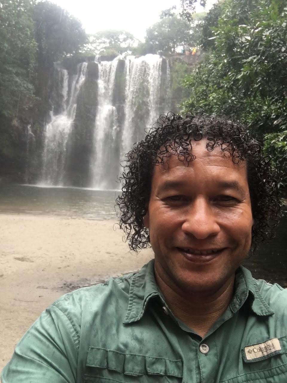 Nolberto smiling in front of a waterfall